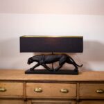 BLACK PANTHER LAMP BASE WITH A BLACK AND GOLD LAMP SHADE