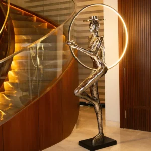 Auric Poise Sculpture floor lamp with golden human figure holding illuminated sphere