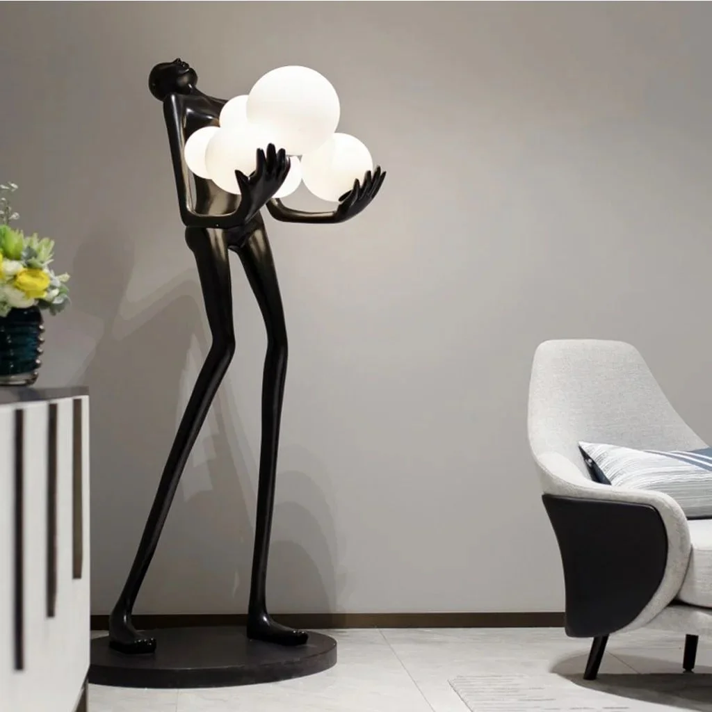 Modern sculpture floor lamp with human figure holding light orbs in contemporary living room