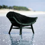 GREEN ARMCHAIR BY RACHEL & BENOIT CONVERS — wide seat formed from closely spaced parallel horizontal slats in deep green, on four angled cross-braced legs, on white background