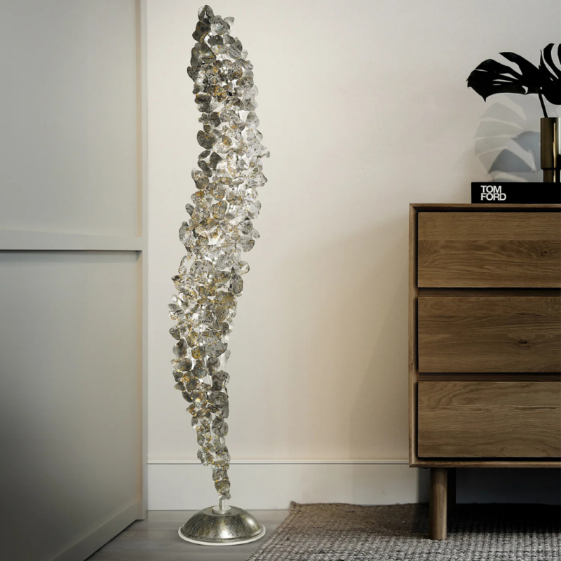 CORTEN METAL FLOOR LAMP WITH SILVER FINISH with overlapping spiral leaf panels glowing amber, 74.8 in tall, styled beside oak dresser