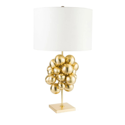 PLUTONE TABLE LAMP with cluster of polished gold spheres on a slim stem and square base topped with a wide ivory drum shade
